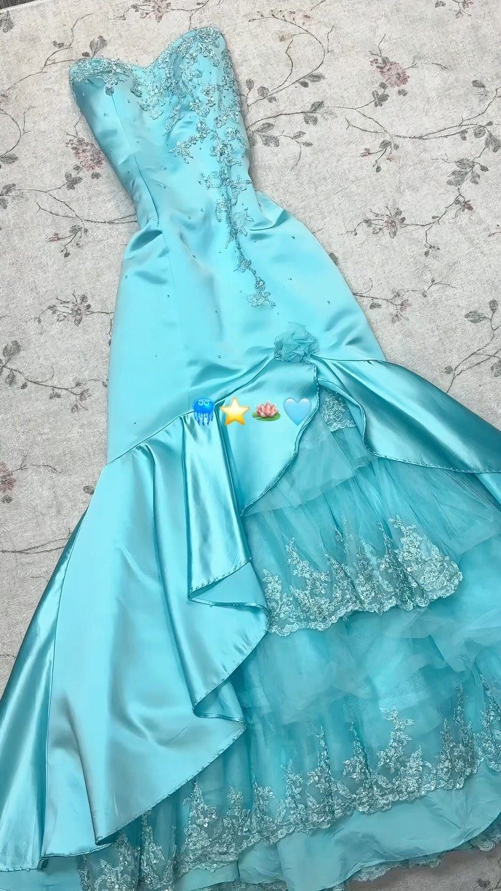 Light blue satin strapless prom dress with silver embroidery and ruffled lace skirt layers.