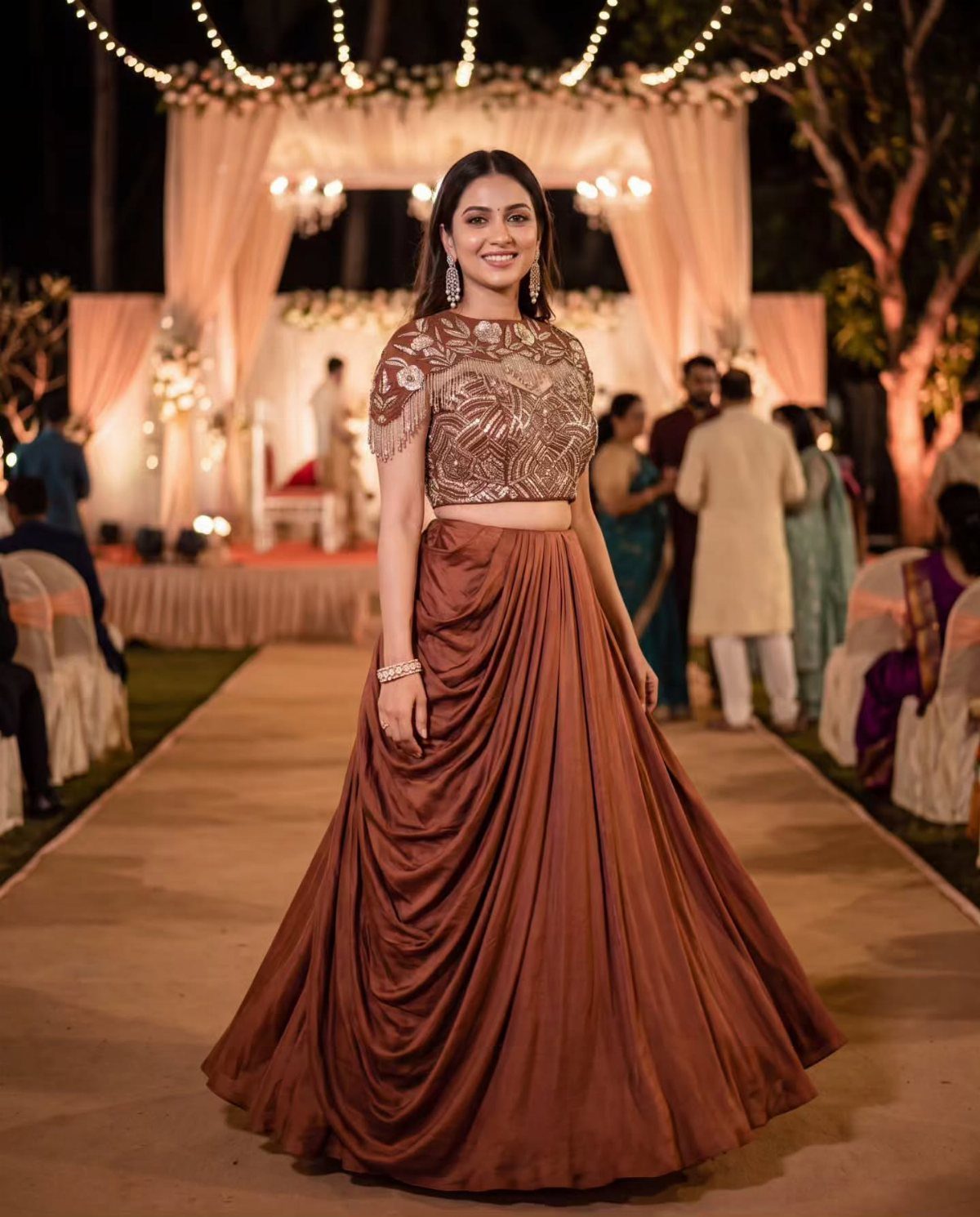 Woman in an embellished copper lehenga posing at an outdoor wedding venue with warm lighting.