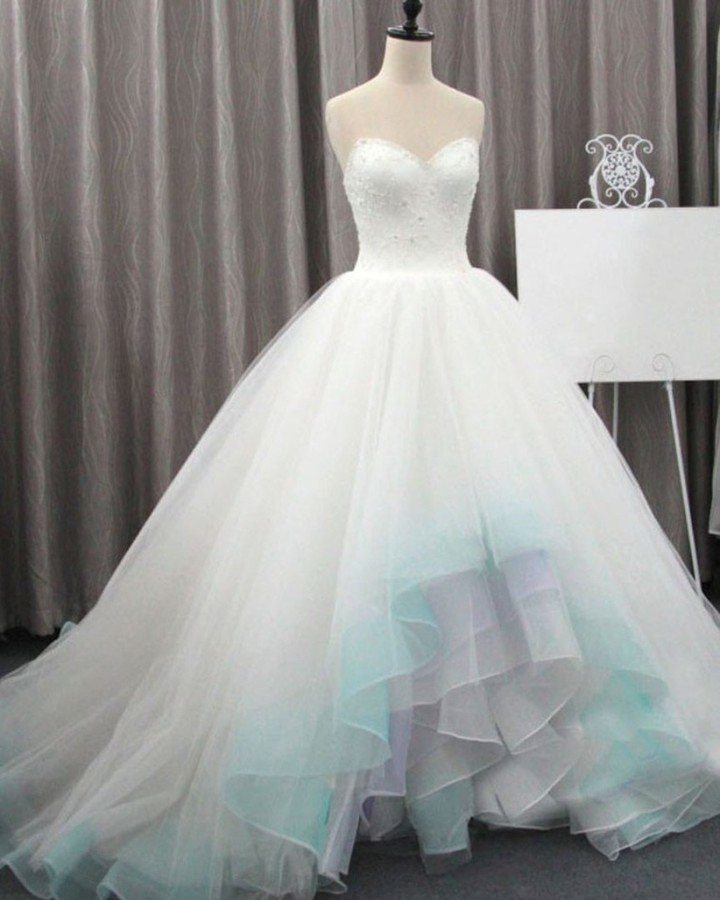A white strapless wedding dress with a mint green ombre tulle skirt on a mannequin.