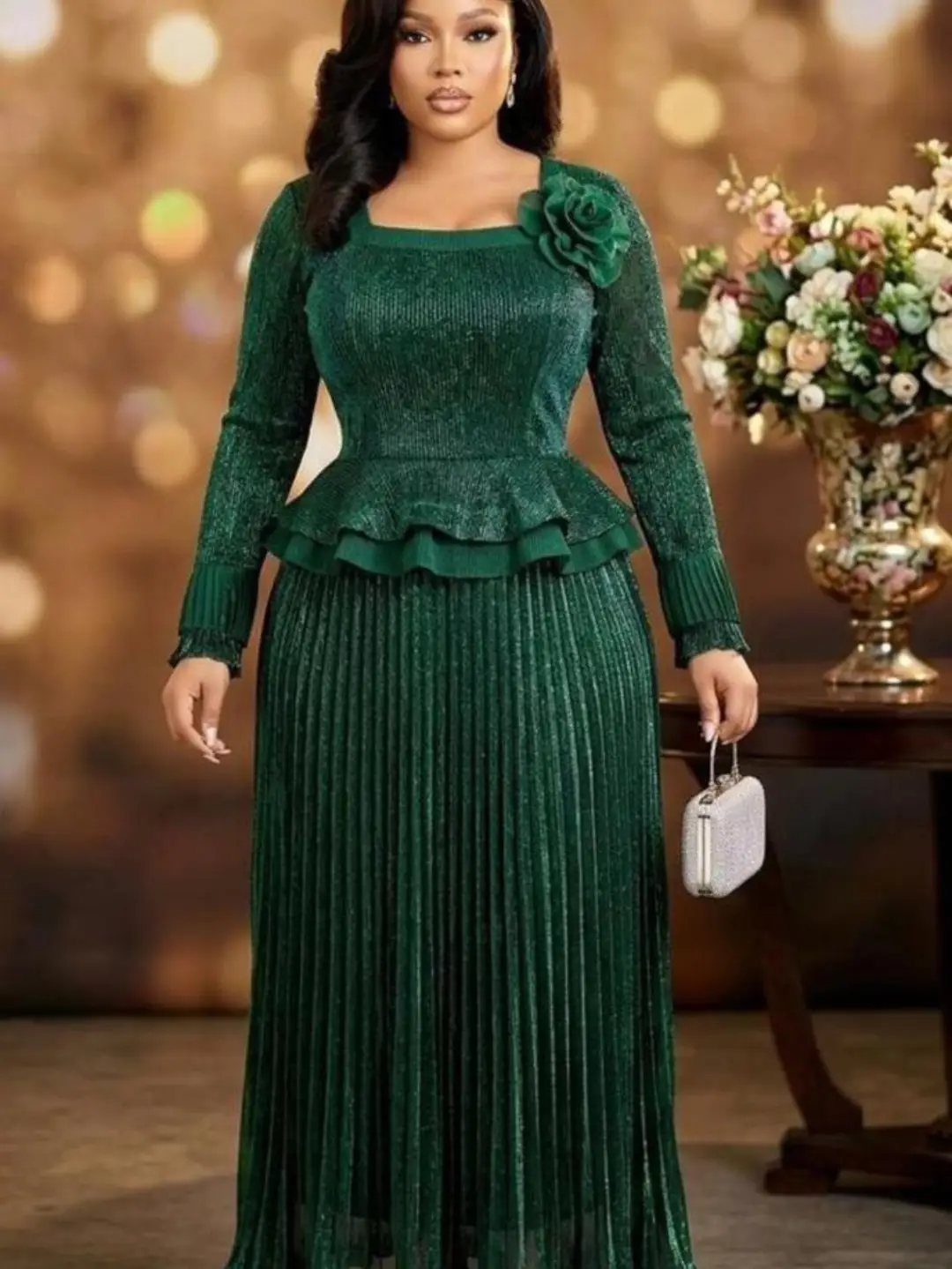 A woman in an elegant emerald green lace peplum dress standing near flowers.