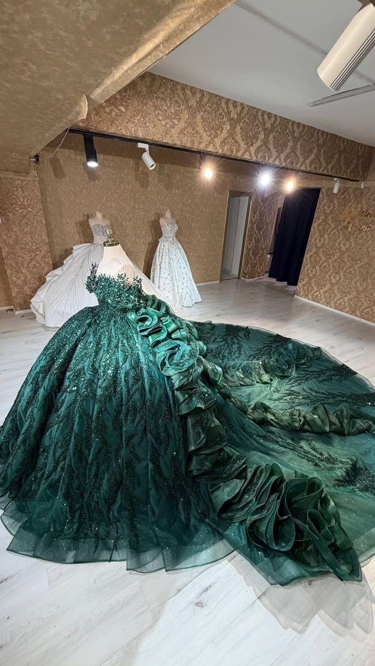 Emerald green wedding dress with large layered ruffles and sparkling details on a mannequin.