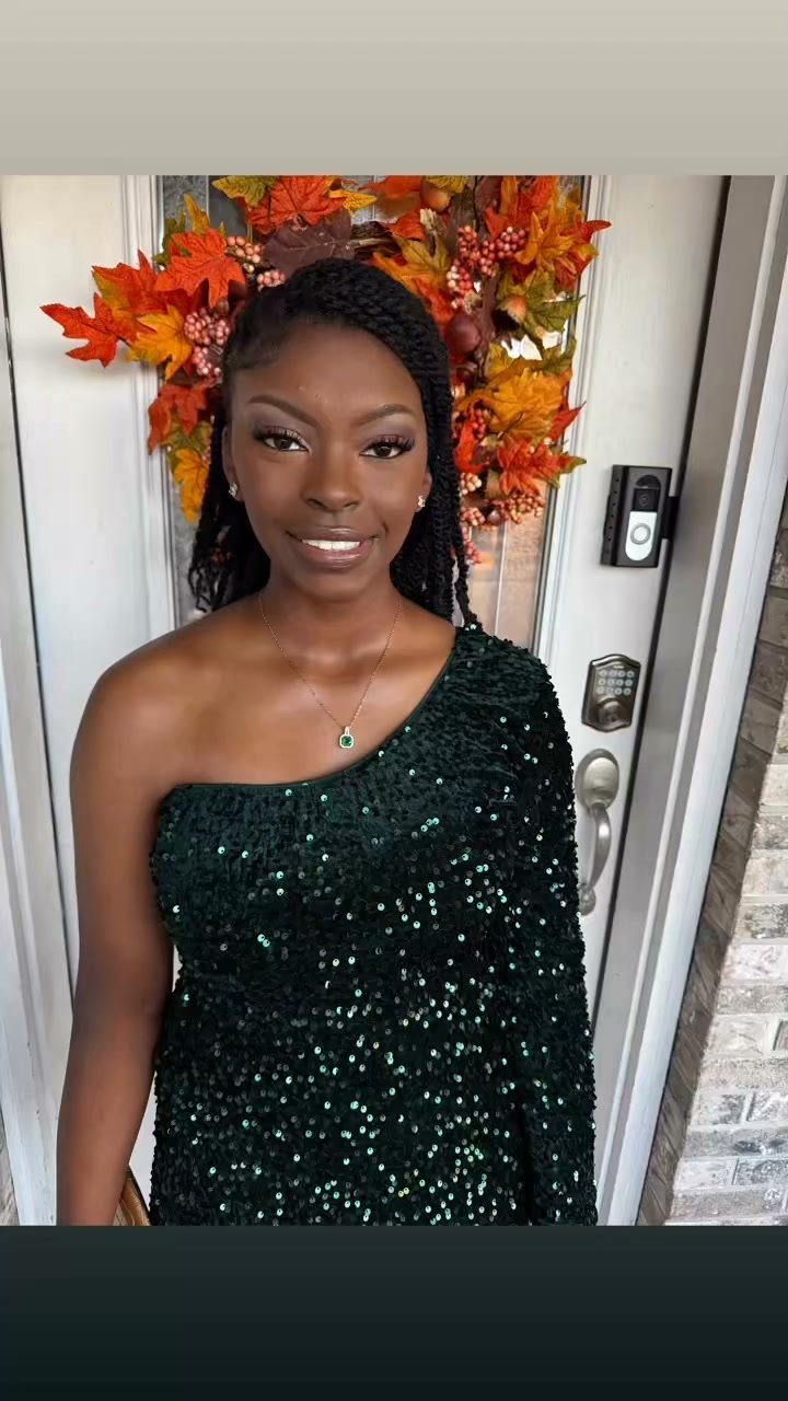 A young woman smiling while wearing a dark green sequined one-shoulder homecoming dress.