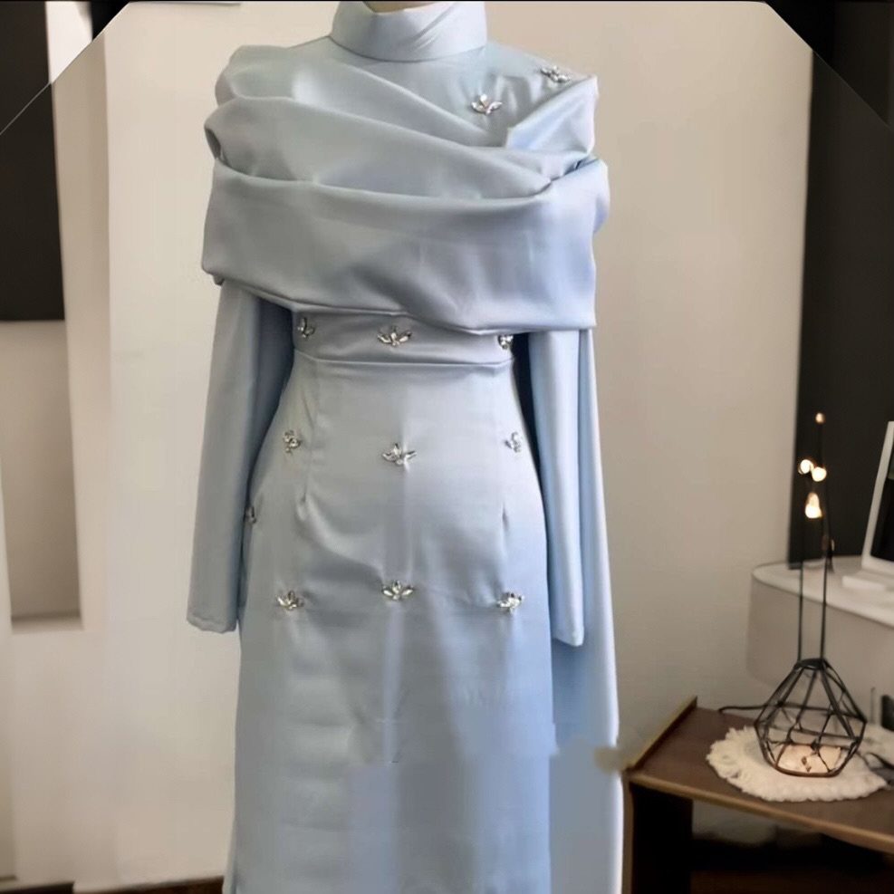 Light blue formal gown with silver embellishments displayed on a mannequin in a room.