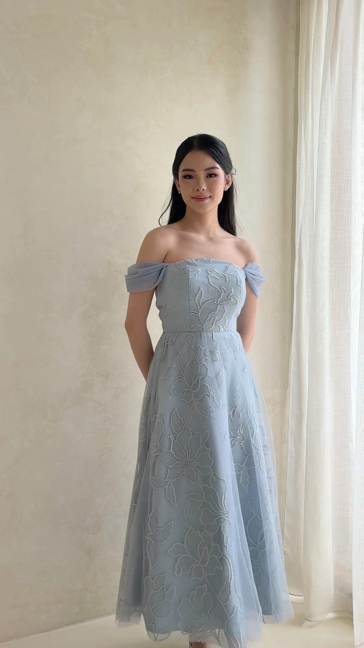 Woman in a light blue off-the-shoulder A-line formal dress with floral embroidery.