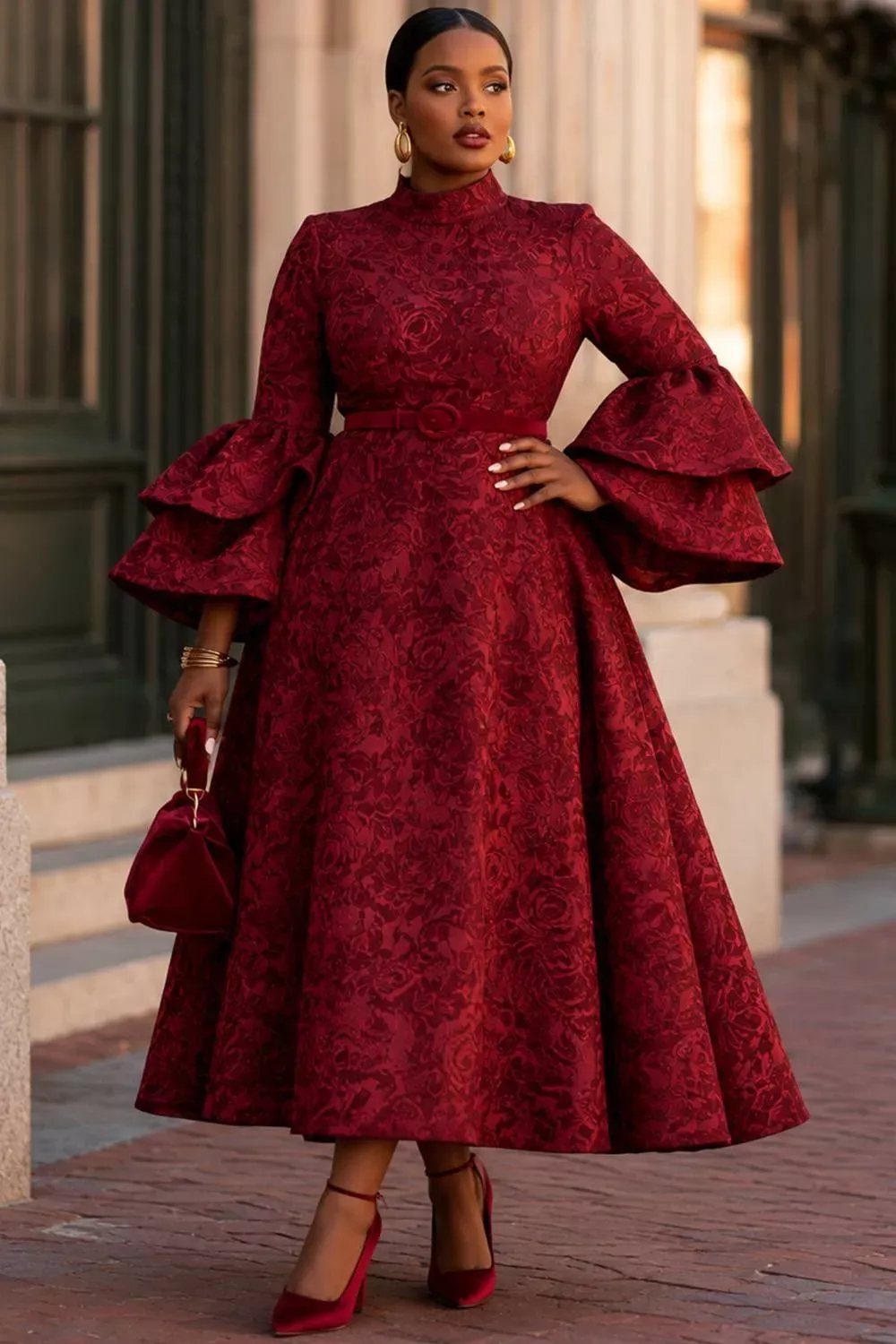 Woman in a burgundy long-sleeve floral textured dress with large puffed sleeves standing outdoors.
