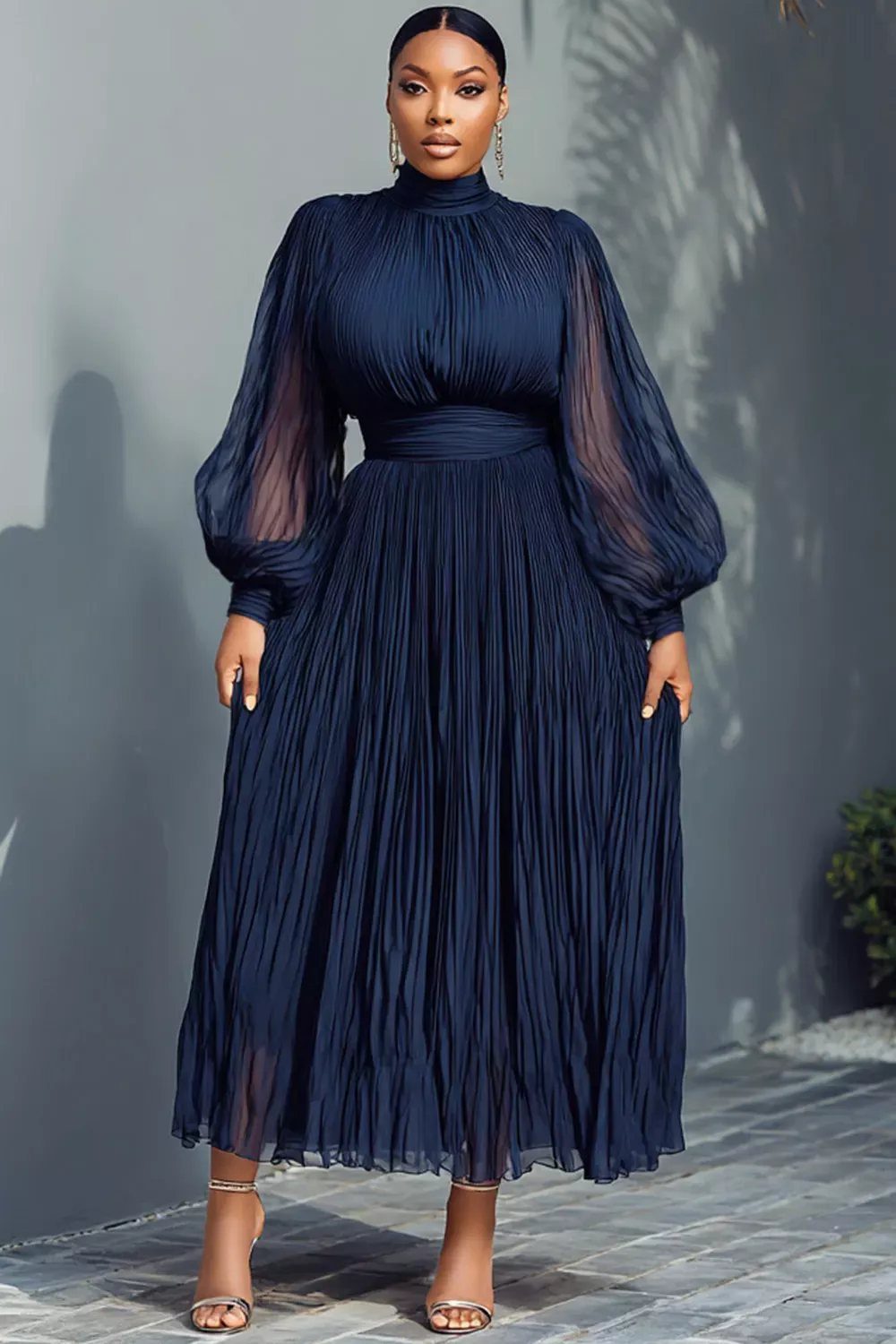 Woman wearing an elegant navy blue pleated chiffon maxi dress with balloon sleeves and high neck.