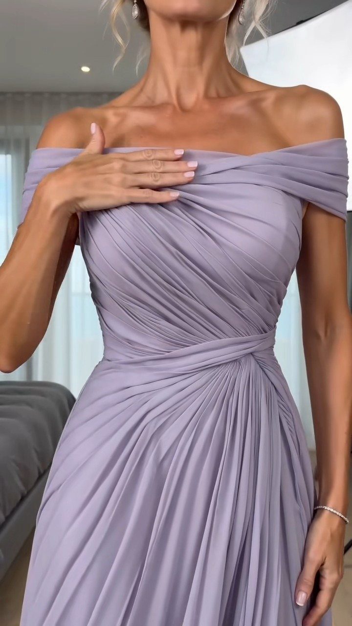 Woman wearing a lavender off-the-shoulder pleated chiffon dress with ruched detailing.