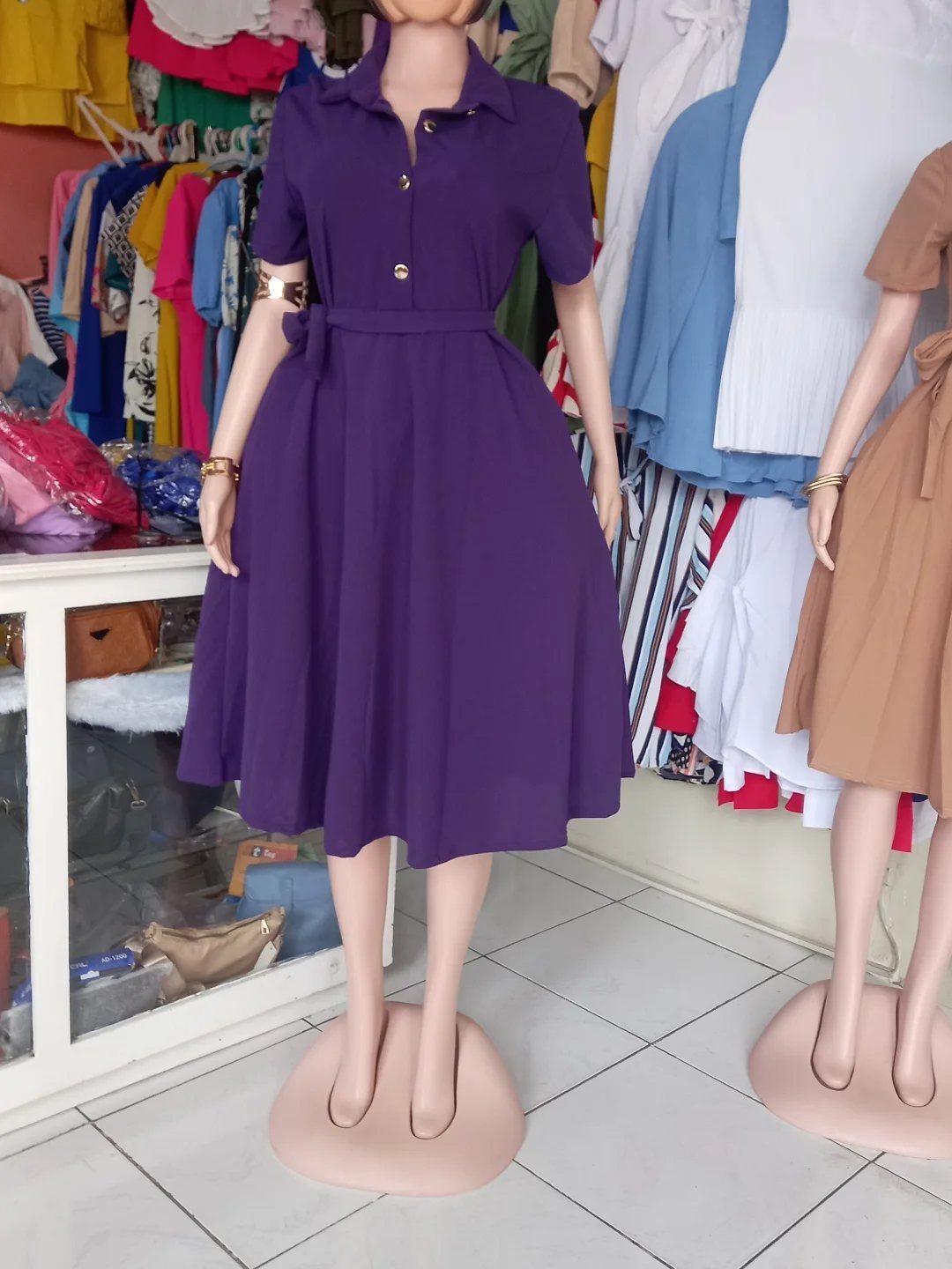 Purple short-sleeved button-down dress with a waist tie displayed on a mannequin.