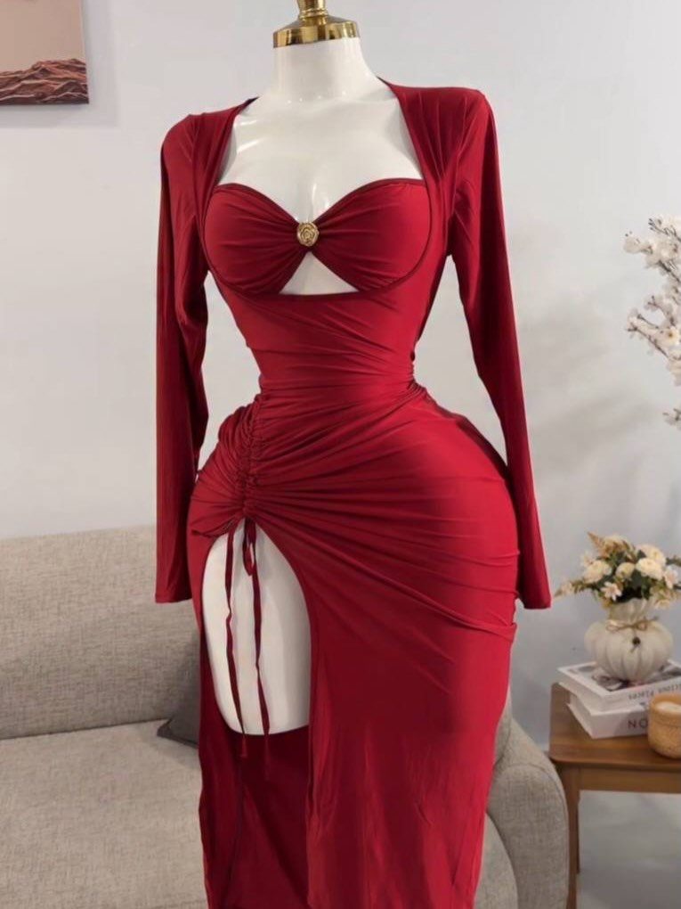 Red satin gown with long sleeves and a small cutout under the bust on a mannequin.