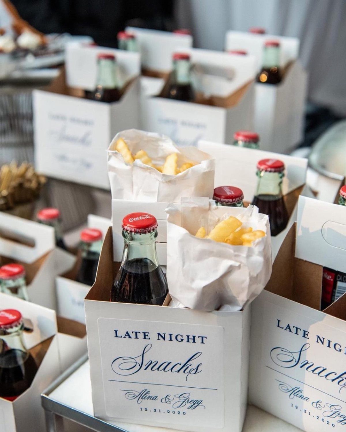 White snack boxes filled with glass cola bottles and paper bags of french fries.
