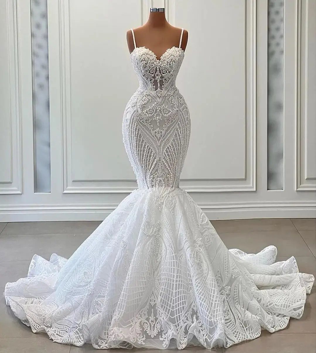 A white lace mermaid wedding dress with a sweetheart neckline on a mannequin.