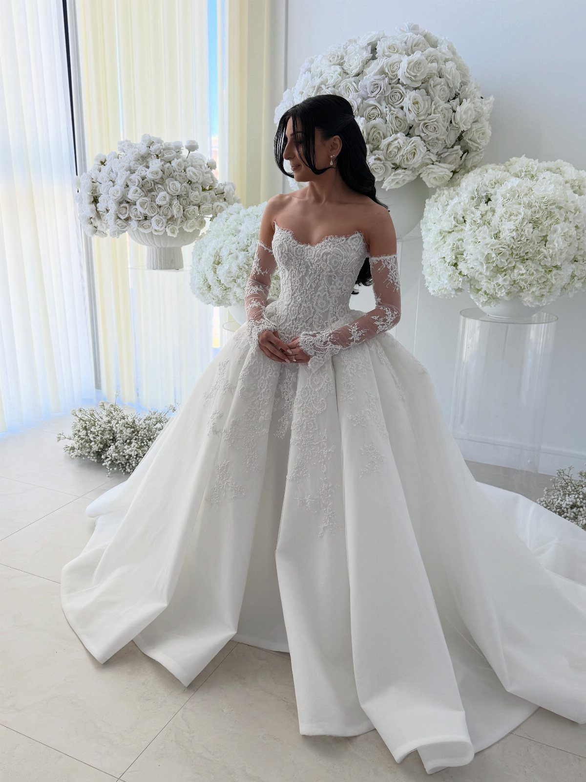 Woman in a white lace corset wedding gown with a voluminous ballgown skirt.