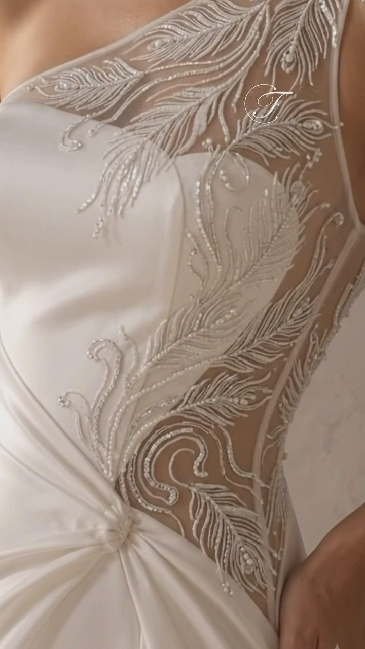 White wedding dress with shimmering crystal and bead feather embroidery on sheer mesh.