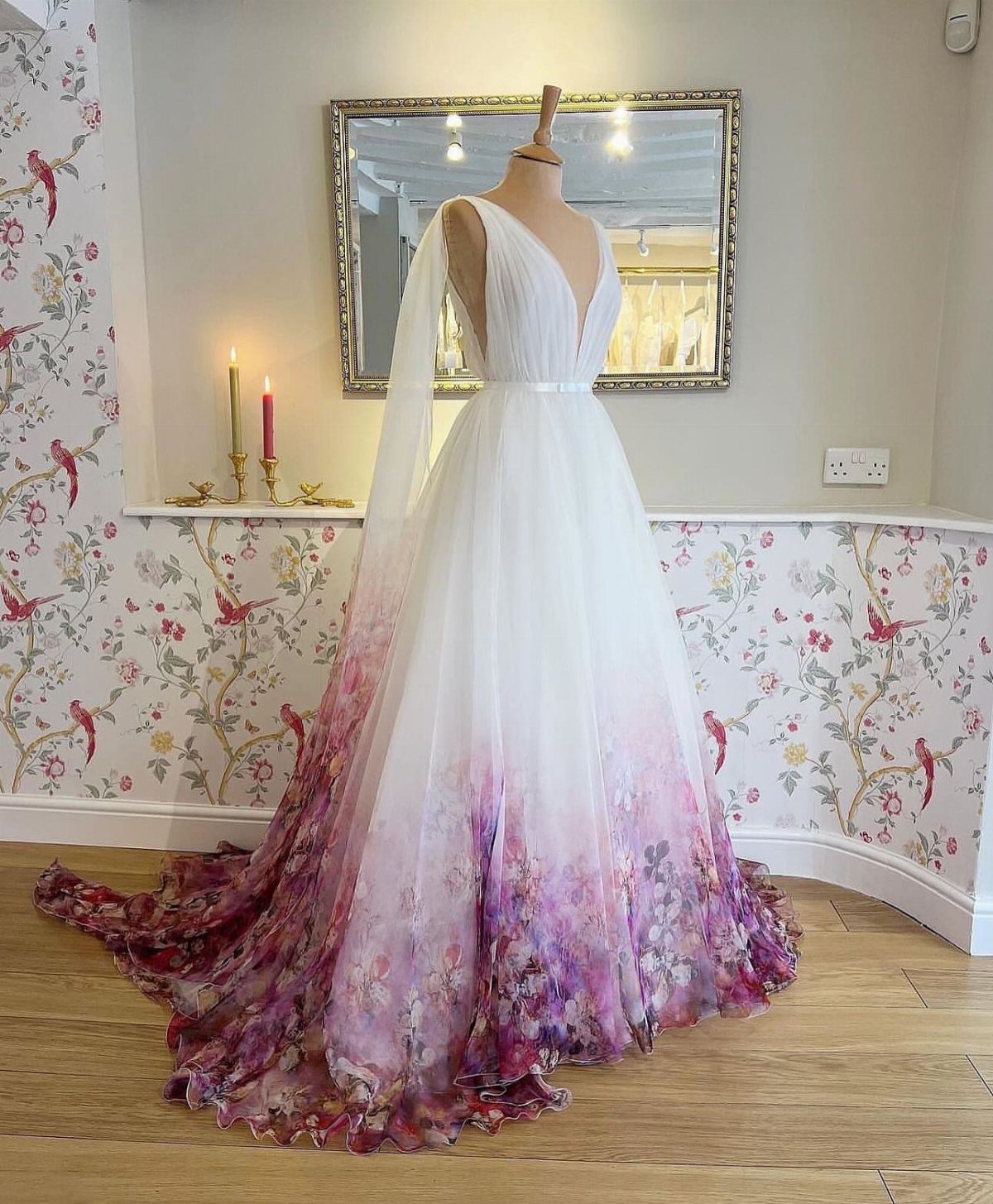 White wedding gown with a purple and pink floral watercolor pattern on the skirt and train.