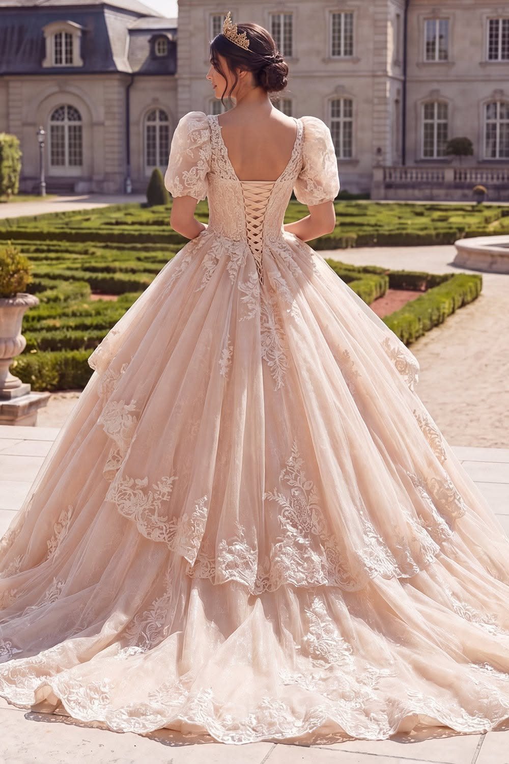 Woman in a voluminous champagne princess ballgown with lace and a crown